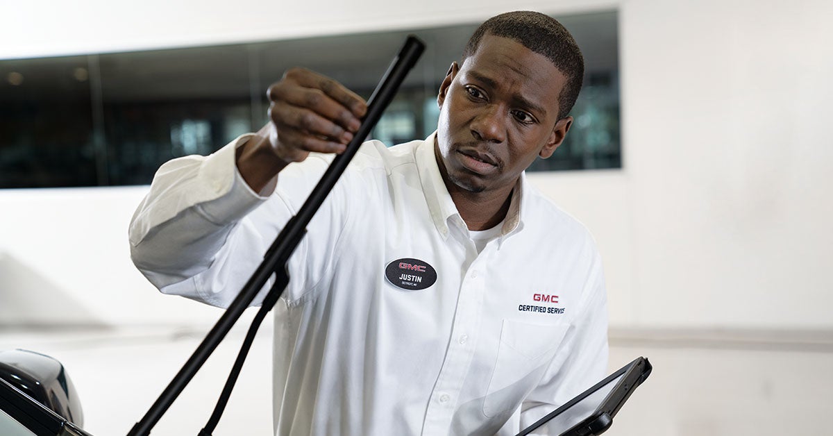 GMC service tech inspecting windshield wipers