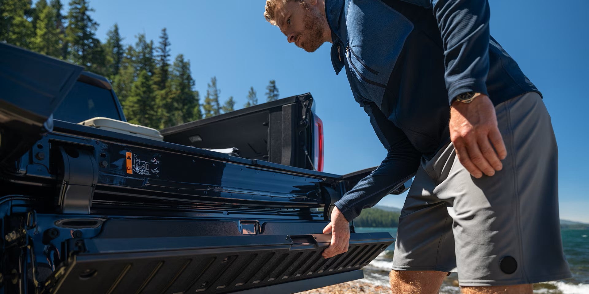 Demonstration of the multi-function GMC MultiPro Tailgate configured as a full-width integrated step on a 2026 GMC Sierra 1500